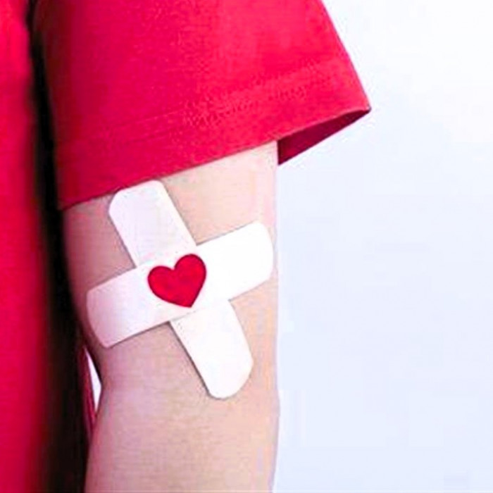 χέρι με τσιρότο και κόκκινη καρδιά